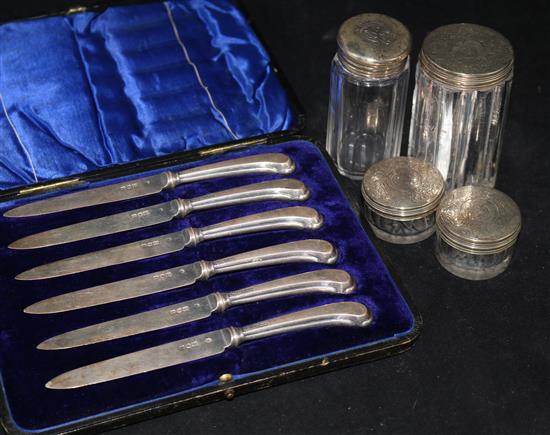 Four Victorian silver topped toilet jars and a cased set of six pistol handled cake knives.